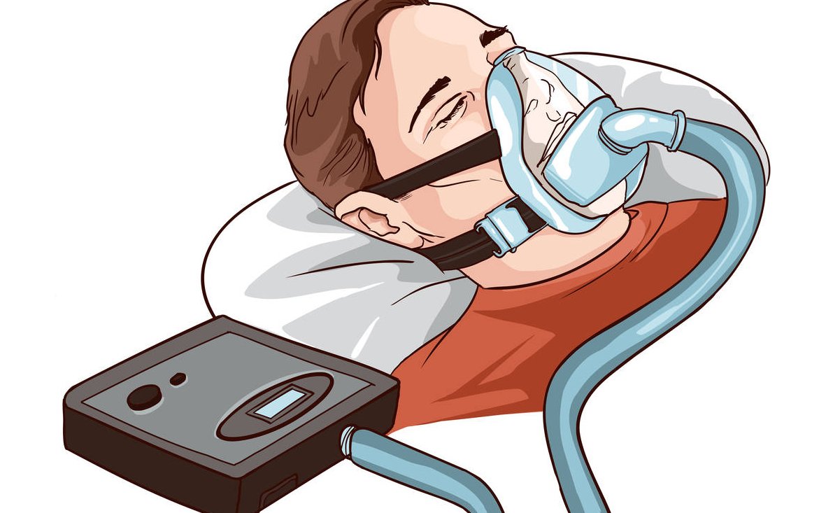 Young Man Lying On Bed With Sleeping Apnea And CPAP